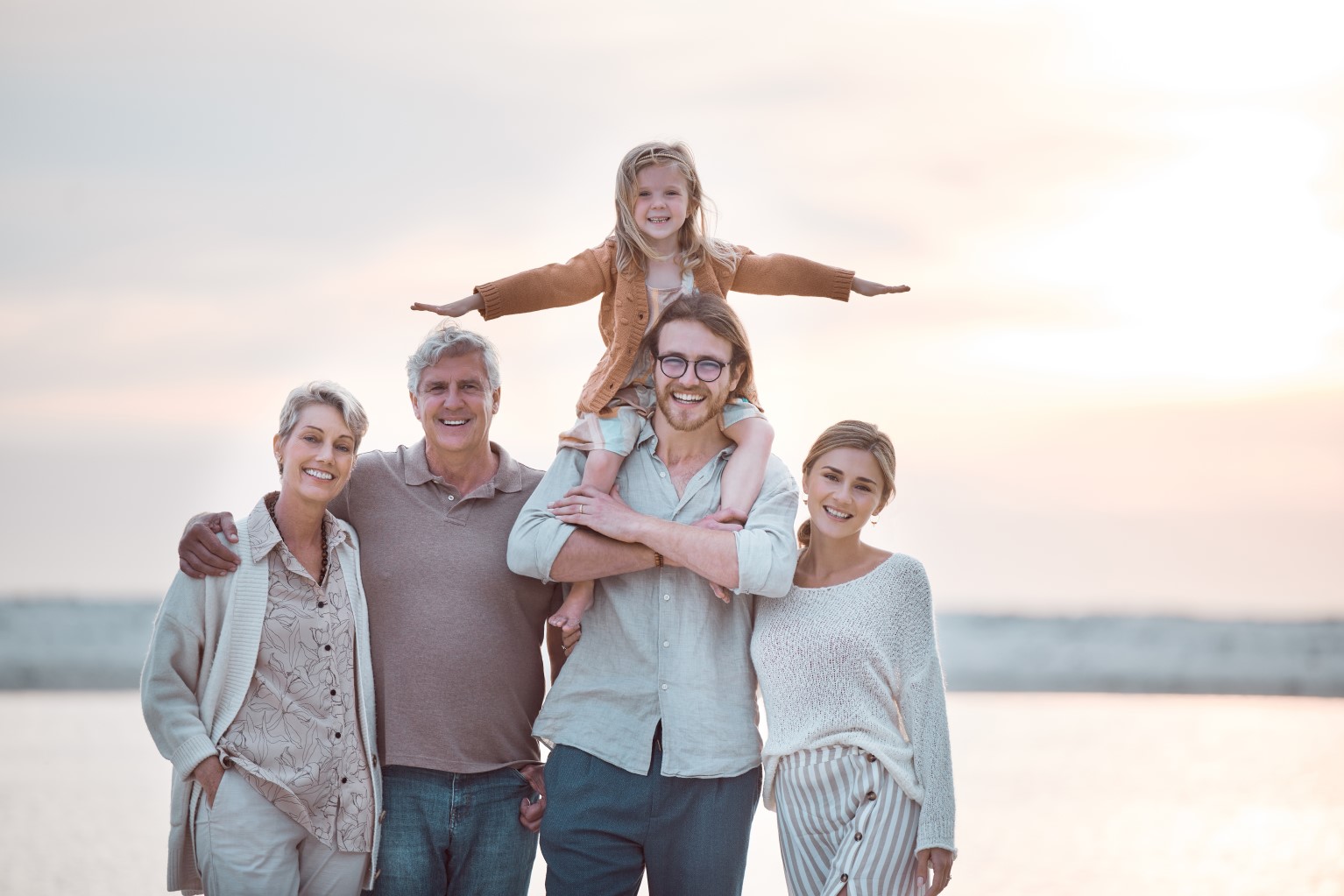 Portrait of grandparents, parents and kid on beach